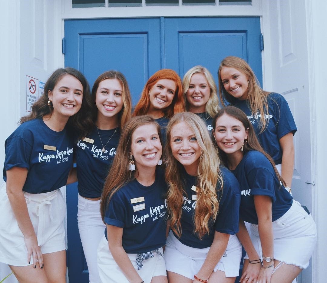 eight chapter members pose in front of a door during recruitment