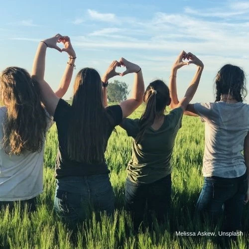 four people making two hearts with their hands