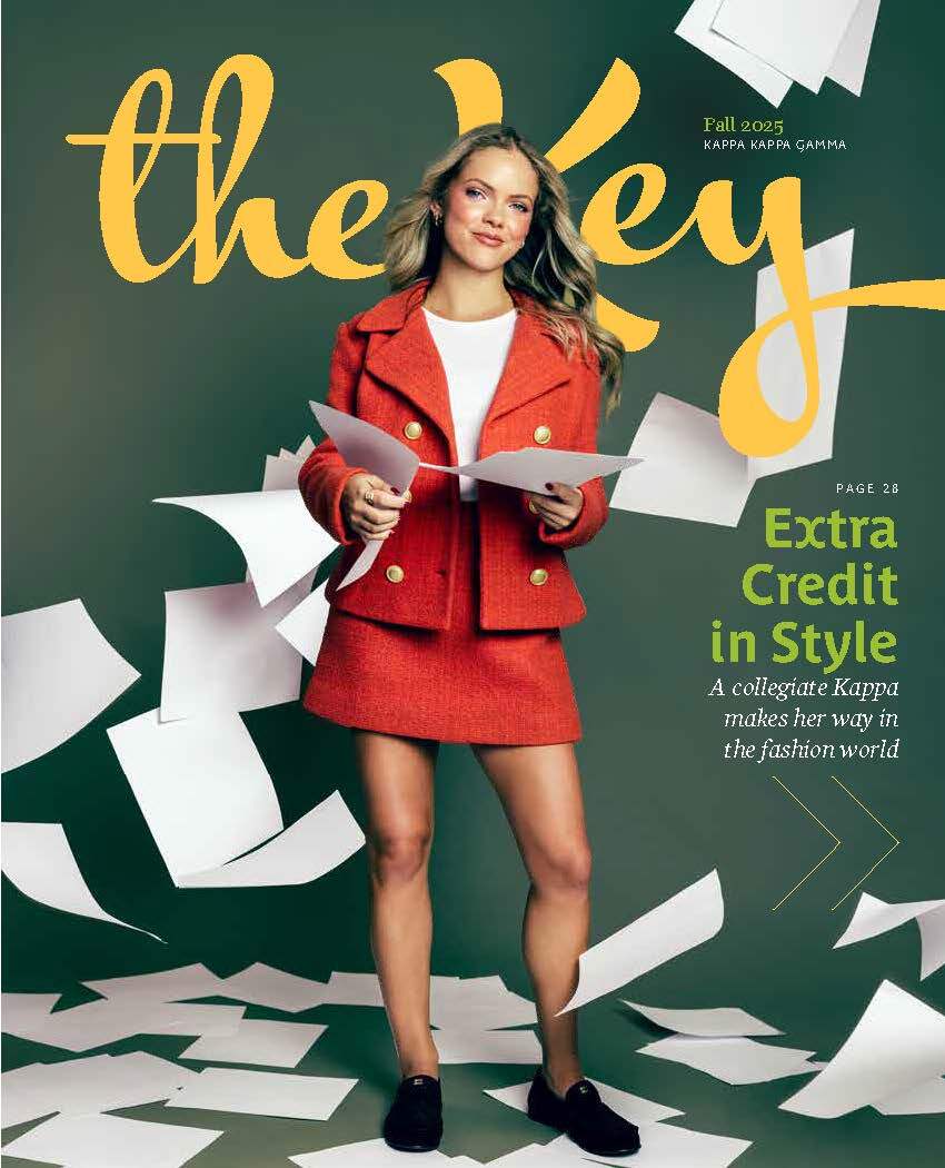 Kappa Kappa Gamma. Girl wearing a red jacket and skirt holding white papers.